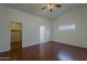 This bedroom offers wood-style flooring, ceiling fan, and a walk in closet at 15905 W Saguaro Ln, Surprise, AZ 85374