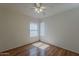 Well-lit bedroom boasts hardwood floors, a ceiling fan, and a window for natural light at 15905 W Saguaro Ln, Surprise, AZ 85374