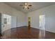 Large bedroom has wood-style flooring, ceiling fan, and multiple doors at 15905 W Saguaro Ln, Surprise, AZ 85374