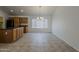 Bright dining room featuring tile flooring, wooden cabinets, a chandelier, and a large window at 15905 W Saguaro Ln, Surprise, AZ 85374