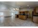 Open kitchen and living room area with tile flooring, wooden cabinets, and modern appliances at 15905 W Saguaro Ln, Surprise, AZ 85374