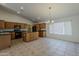 Spacious kitchen featuring tile flooring, wooden cabinets, black appliances, and a large island at 15905 W Saguaro Ln, Surprise, AZ 85374