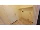 A functional laundry room with tiled floors and a built-in shelf ready for organizing essentials at 15905 W Saguaro Ln, Surprise, AZ 85374