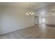 Bright living room and kitchen area with tile flooring and a modern chandelier at 15905 W Saguaro Ln, Surprise, AZ 85374