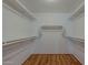 Good view of a walk-in closet with custom shelving and wood flooring at 15905 W Saguaro Ln, Surprise, AZ 85374
