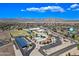 Expansive aerial shot of a community with mountain views, schools, solar paneled carports, and residential area at 18045 W Rimrock St, Surprise, AZ 85388