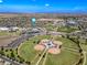 Wide aerial view featuring baseball fields, school buildings with solar panels, and distant desert landscape at 18045 W Rimrock St, Surprise, AZ 85388