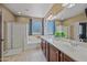 Bright bathroom with dual sinks, bathtub, walk-in shower, and large window at 18045 W Rimrock St, Surprise, AZ 85388