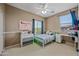 Comfortable bedroom featuring a ceiling fan, large window, and a cozy bed with themed decor at 18045 W Rimrock St, Surprise, AZ 85388