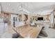 Open concept dining area featuring modern lighting, a wooden table, and a seamless flow to the kitchen and living spaces at 18045 W Rimrock St, Surprise, AZ 85388