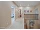 Bright hallway featuring neutral tones with access to bedrooms, bathroom, and staircase at 18045 W Rimrock St, Surprise, AZ 85388