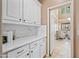 Bright kitchen features white cabinets, marble countertops, and an open doorway to a welcoming living space at 18045 W Rimrock St, Surprise, AZ 85388
