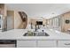 Kitchen featuring white cabinets, stainless steel appliances, and an island with a sink and marble countertop at 18045 W Rimrock St, Surprise, AZ 85388