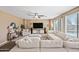 Bright living room offers lots of seating, a ceiling fan, and a view to the backyard through large windows at 18045 W Rimrock St, Surprise, AZ 85388