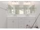 Bathroom featuring dual vanities, quartz countertops, and a large mirror at 20262 W Monterey Way, Buckeye, AZ 85396
