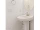 Modern bathroom with pedestal sink, round mirror, and decorative lighting fixture at 20262 W Monterey Way, Buckeye, AZ 85396