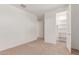 Carpeted bedroom with hallway access and open closet at 20262 W Monterey Way, Buckeye, AZ 85396