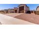 Two-story home boasts a terracotta roof, paired garages, and a driveway paved with decorative pavers at 20262 W Monterey Way, Buckeye, AZ 85396