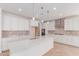 Bright kitchen featuring a large quartz island, stainless appliances, and stylish pendant lighting at 20262 W Monterey Way, Buckeye, AZ 85396