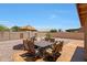 This backyard patio features a stone dining table and umbrella with desert landscaping, and block fence at 20739 N 106Th Ave, Peoria, AZ 85382