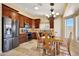 Well-lit kitchen with dark wood cabinets, stainless steel appliances, and a dining area at 20739 N 106Th Ave, Peoria, AZ 85382