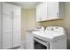 Laundry room with ample white storage cabinets and modern appliances at 20739 N 106Th Ave, Peoria, AZ 85382