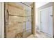 Glass-enclosed shower featuring tile surround, bench, and hand rails at 20739 N 106Th Ave, Peoria, AZ 85382