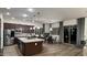 Gourmet kitchen with a center island, dark wood cabinetry, stainless appliances, and adjacent dining area at 2121 E Aquarius Pl, Chandler, AZ 85249