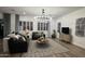 Chic living room with modern chandelier, neutral decor, plantation shutters, and comfortable leather seating at 2121 E Aquarius Pl, Chandler, AZ 85249