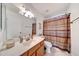 Well-lit bathroom featuring a light wood vanity and stylish shower curtain at 23638 N 41St Ave, Glendale, AZ 85310