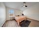 Bright bedroom with wood-look floors, ceiling fan, and desk space at 23638 N 41St Ave, Glendale, AZ 85310