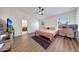 A bright bedroom with wood-look floors, ceiling fan, and attached bathroom at 23638 N 41St Ave, Glendale, AZ 85310