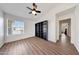 Bright bedroom with ceiling fan, wood-look floors, and built in shelves at 23638 N 41St Ave, Glendale, AZ 85310