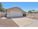 Side view of a single-story home with a desert-style yard, featuring a two-car garage and a well-kept lawn at 23638 N 41St Ave, Glendale, AZ 85310