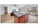 Kitchen island with dark countertops, wooden cabinets, and seating faces living area and outdoor views at 23638 N 41St Ave, Glendale, AZ 85310