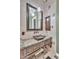 Elegant bathroom featuring stone countertops, a decorative mirror, and stylish fixtures at 2371 E Sanoque Ct, Gilbert, AZ 85298