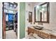 Elegant bathroom with stone countertop, decorative mirror, and adjoining walk-in closet provides a spacious retreat at 2371 E Sanoque Ct, Gilbert, AZ 85298