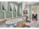 Luxurious bathroom showcasing a soaking tub with a marble surround, elegant window treatments, and refined finishes at 2371 E Sanoque Ct, Gilbert, AZ 85298