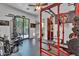 Well-equipped home gym featuring weightlifting equipment, machines, and a glass door leading to the backyard at 2371 E Sanoque Ct, Gilbert, AZ 85298