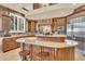 Gourmet kitchen featuring custom cabinetry, a large island with seating, and stainless steel appliances at 2371 E Sanoque Ct, Gilbert, AZ 85298