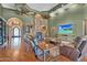 Cozy living room with a stone fireplace, hardwood floors, and a flat-screen TV at 2371 E Sanoque Ct, Gilbert, AZ 85298