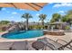 Lounge by the inviting pool with rock waterfall, slide, and a cabana bar for outdoor entertainment at 2371 E Sanoque Ct, Gilbert, AZ 85298