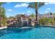 Rock waterfall and slide feature add fun to this sparkling blue pool with desert landscaping at 2371 E Sanoque Ct, Gilbert, AZ 85298