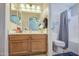 Well-lit bathroom features a wood vanity with modern fixtures and a shower with curtain at 24035 W La Salle St, Buckeye, AZ 85326