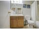 Bathroom with vanity, mirror, and white shower curtain next to a toilet at 24035 W La Salle St, Buckeye, AZ 85326