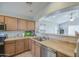 Bright kitchen with countertops, wood cabinets, stainless appliances, and a serving hatch at 24035 W La Salle St, Buckeye, AZ 85326