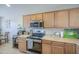 Bright kitchen featuring countertops, wood cabinets, stainless appliances, and tile flooring at 24035 W La Salle St, Buckeye, AZ 85326