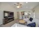 Comfortable living room with a large television, ceiling fan, and view of breakfast bar at 24035 W La Salle St, Buckeye, AZ 85326