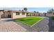 Serene backyard with artificial turf, desert landscaping, and a covered patio area for relaxation and entertaining at 2525 E Nisbet Rd, Phoenix, AZ 85032
