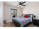 Comfortable bedroom with a dark-toned bed, ceiling fan, and natural light at 2525 E Nisbet Rd, Phoenix, AZ 85032